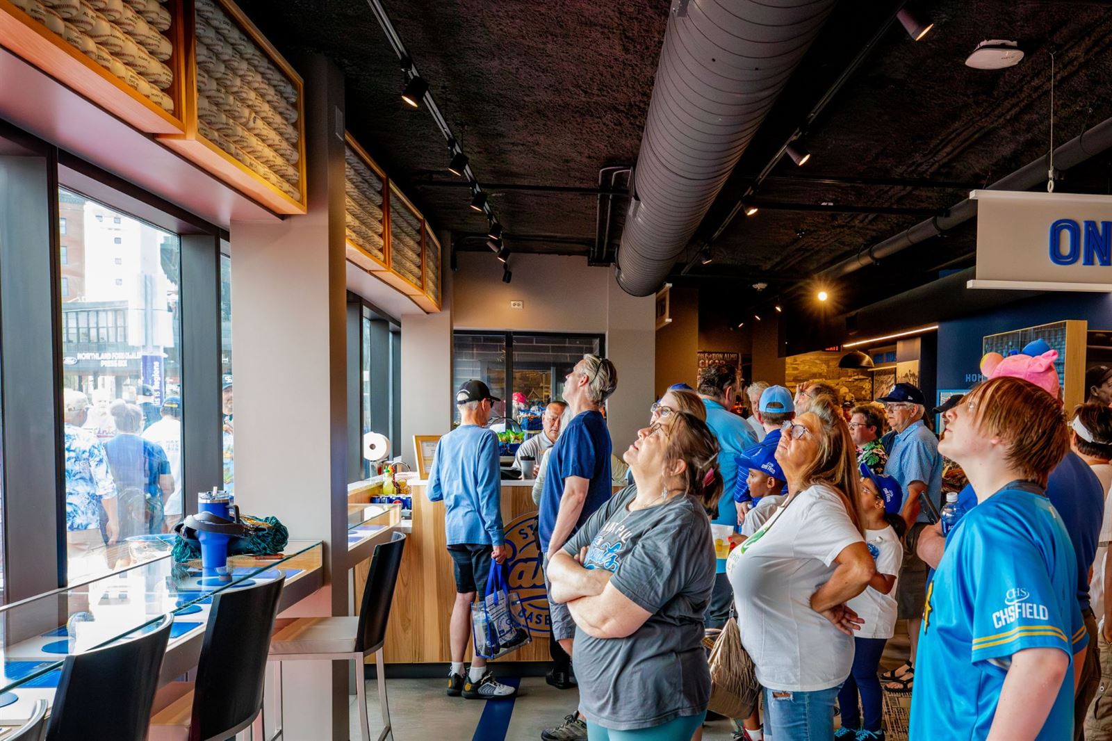 Members looking up at the wall of signed baseballs